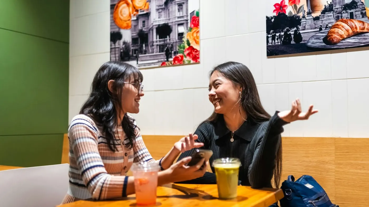 Dos amigas conversan en la mesa de un café